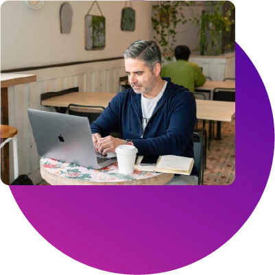 Man using his MacBook while eating at a restaurant 